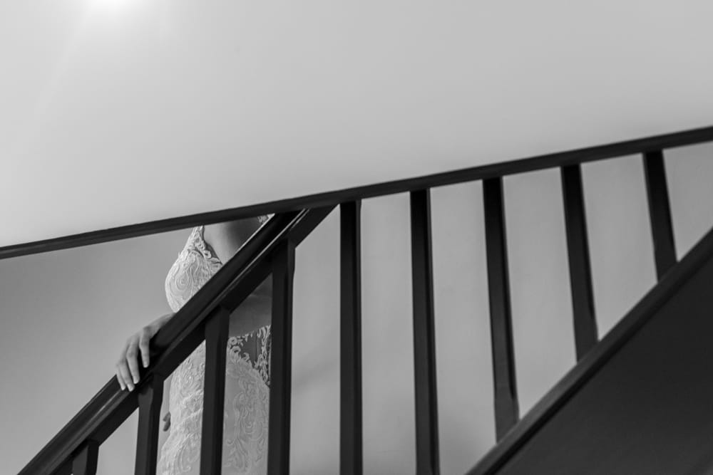 bride coming down steps in her wedding dress