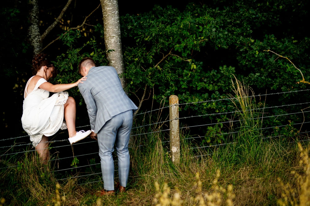 bride climbing over the fence