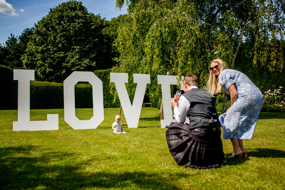 a couple taking pictures of their baby, next to the giant love letters